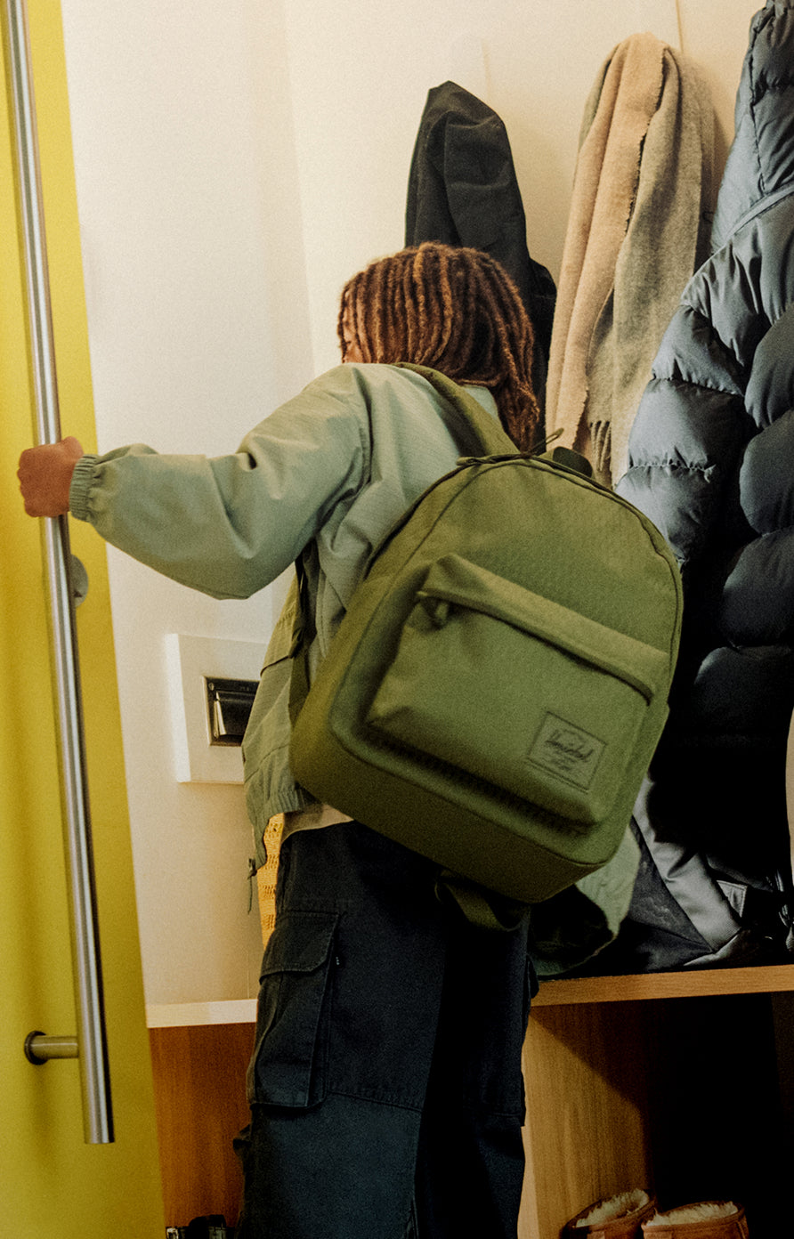 Student heading out with a green backpack